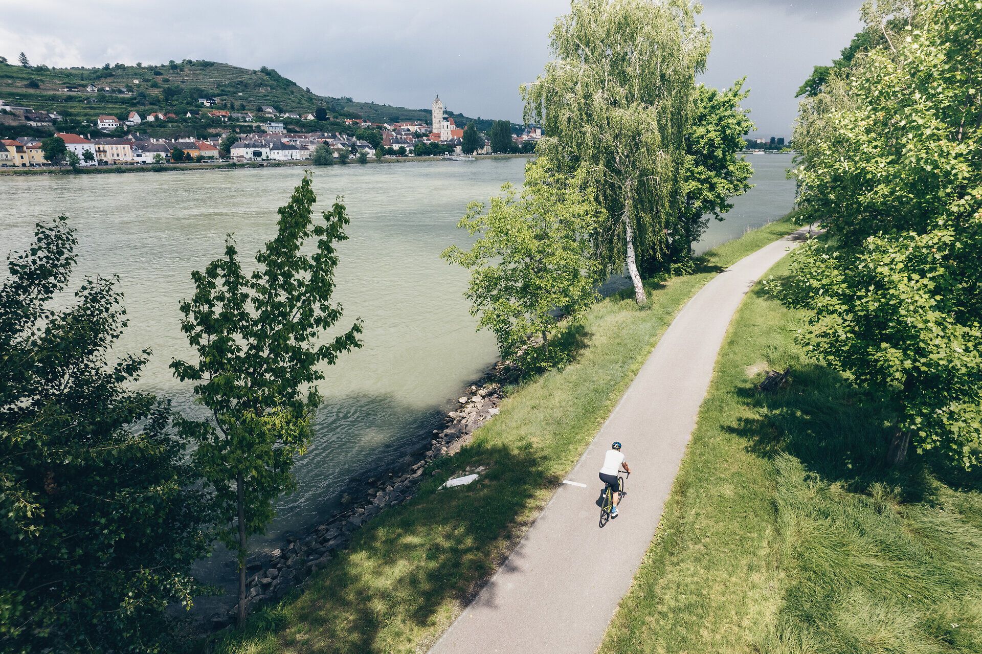 Ein malerischer Radweg schlängelt sich entlang der Donau, umgeben von üppigem Grün und sanften Hügeln. Die ruhige Atmosphäre lädt dazu ein, die Schönheit der Natur zu genießen und die frische Luft zu atmen. Ideal für einen entspannten Ausflug in die idyllische Landschaft Niederösterreichs.