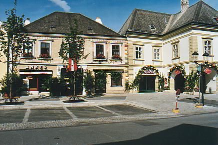 Historische Gebäude mit Geschäften und dekorativen Fassaden an einem sonnigen Tag.