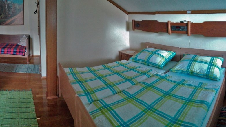 Ein gem&uuml;tliches Zimmer mit Doppelbett, Sofa, Tisch und Fenster.