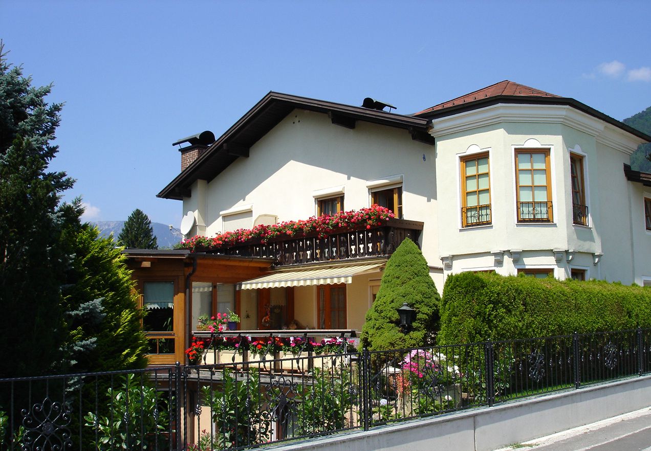 Weißes Haus mit Balkon und Blumen