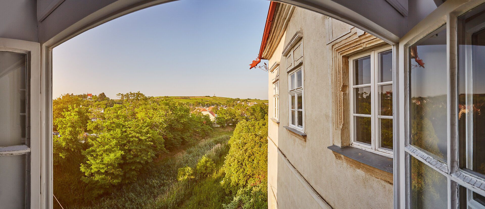 Die sanften Hügel des Weinviertels umarmen das Schloss, während die warmen Sonnenstrahlen die üppige grüne Landschaft erleuchten. Hier, wo die Natur und die Geschichte harmonisch verschmelzen, lädt die Umgebung zu unvergesslichen Erlebnissen ein.