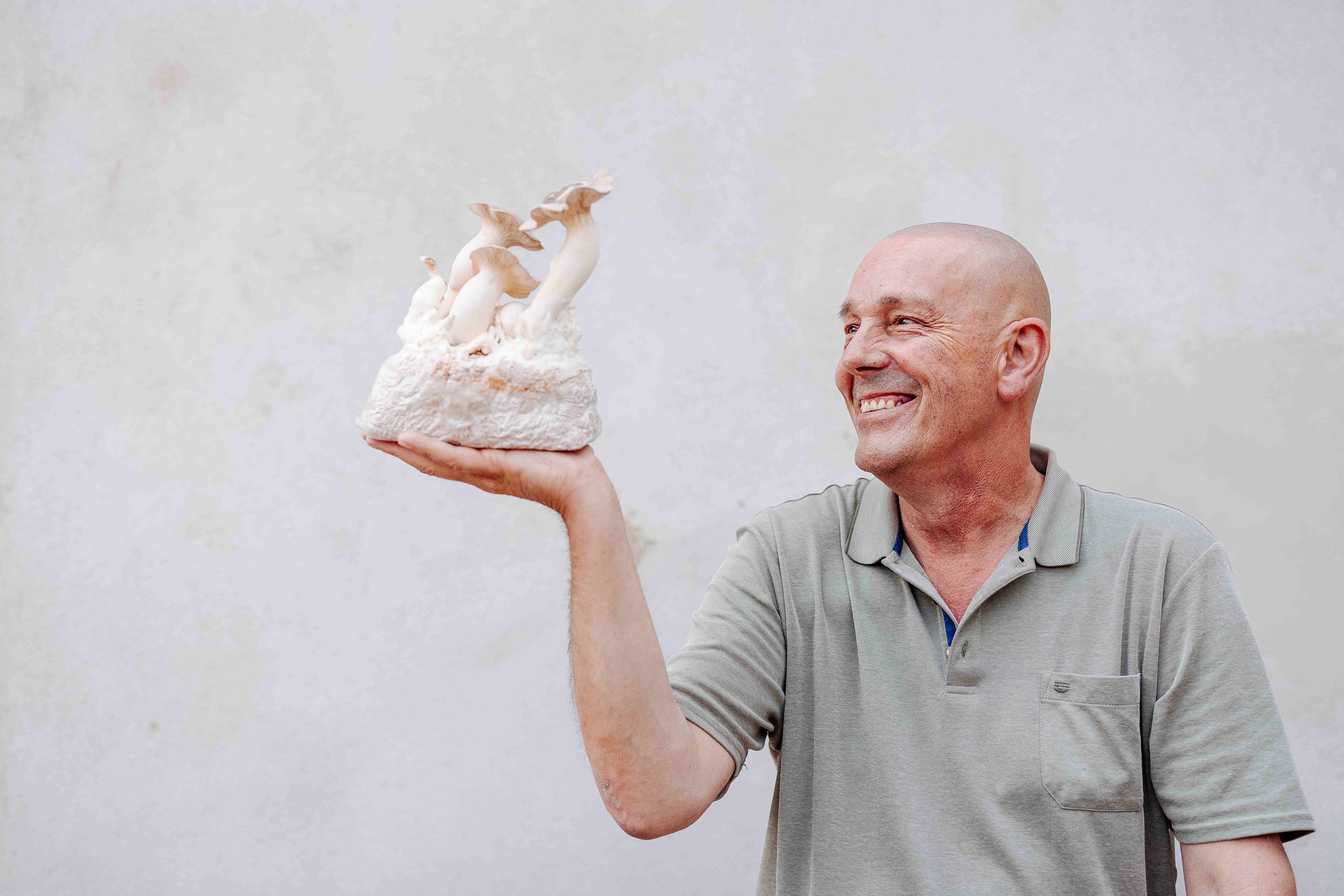 Ein strahlender Mann hält stolz eine exquisite Skulptur in der Hand, die die Schönheit der Natur widerspiegelt. Die sanften Farben und die kunstvolle Gestaltung laden dazu ein, die kulinarischen Köstlichkeiten der Region zu entdecken. Ein perfekter Moment, um die Verbindung zwischen Kunst und Genuss zu feiern.