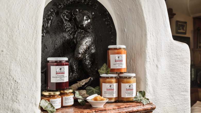 Verschiedene Marmeladengläser vor einem Bärenrelief