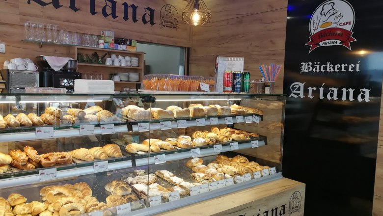 Innenansicht der B&auml;ckerei Ariana mit einer Auslage voller Backwaren.