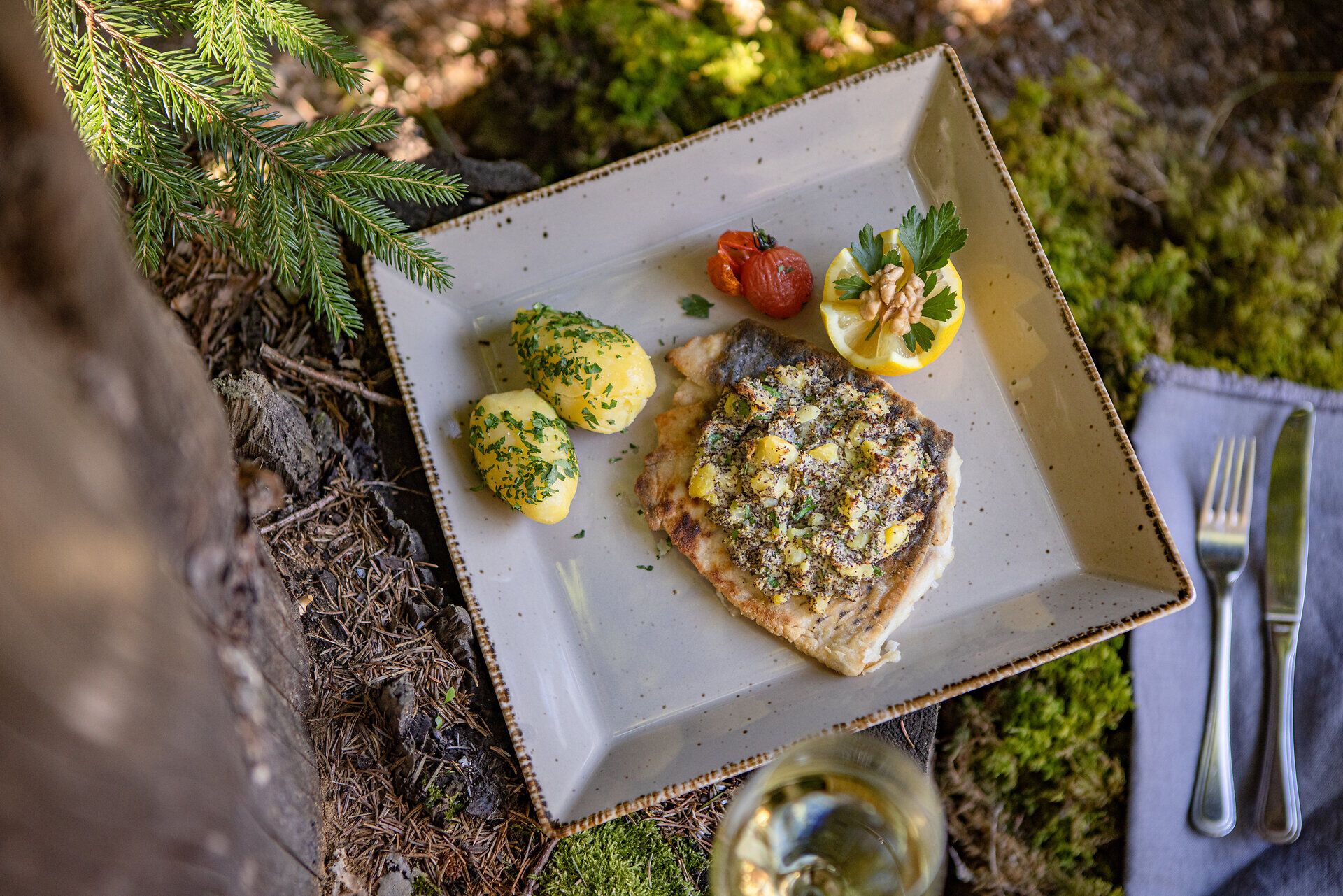 Ein köstlicher Karpfen, liebevoll zubereitet und serviert mit frischen Erdäpfeln und aromatischem Mohn, lädt zu einem genussvollen Moment inmitten der Natur ein. Die rustikale Atmosphäre der Waldschenke Schreiber verspricht ein unvergessliches kulinarisches Erlebnis, das die Sinne verwöhnt.