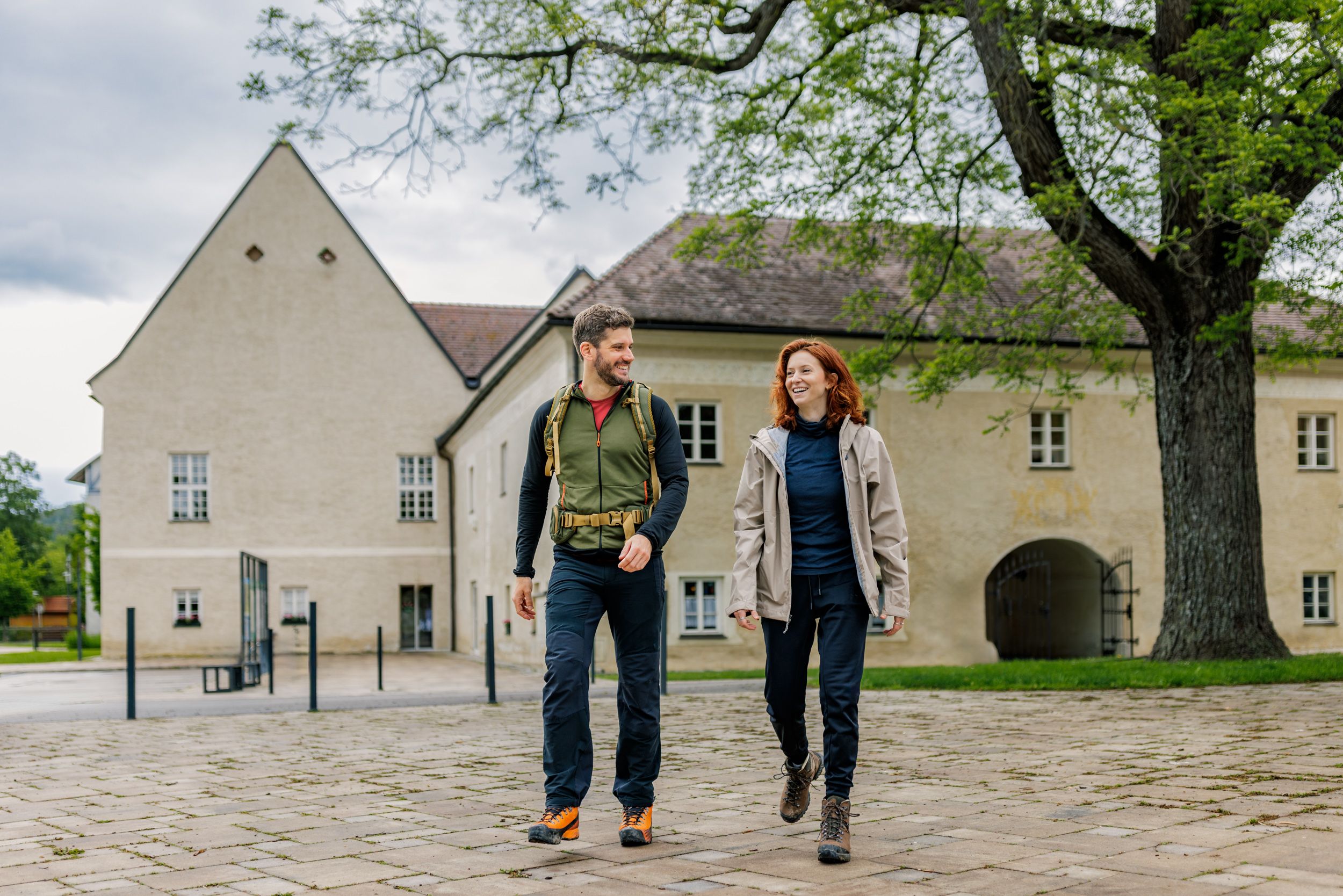 Ein Mann und eine Frau in Wanderkleidung vor dem Schloss Katzelsdorf