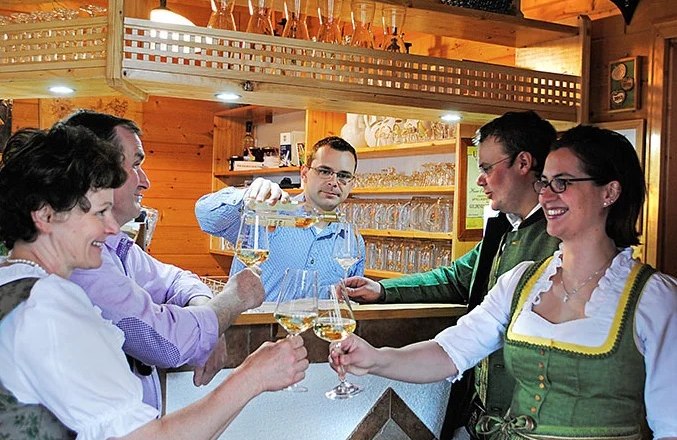 Menschen sto&szlig;en an einer gem&uuml;tlichen Theke mit Getr&auml;nken an.