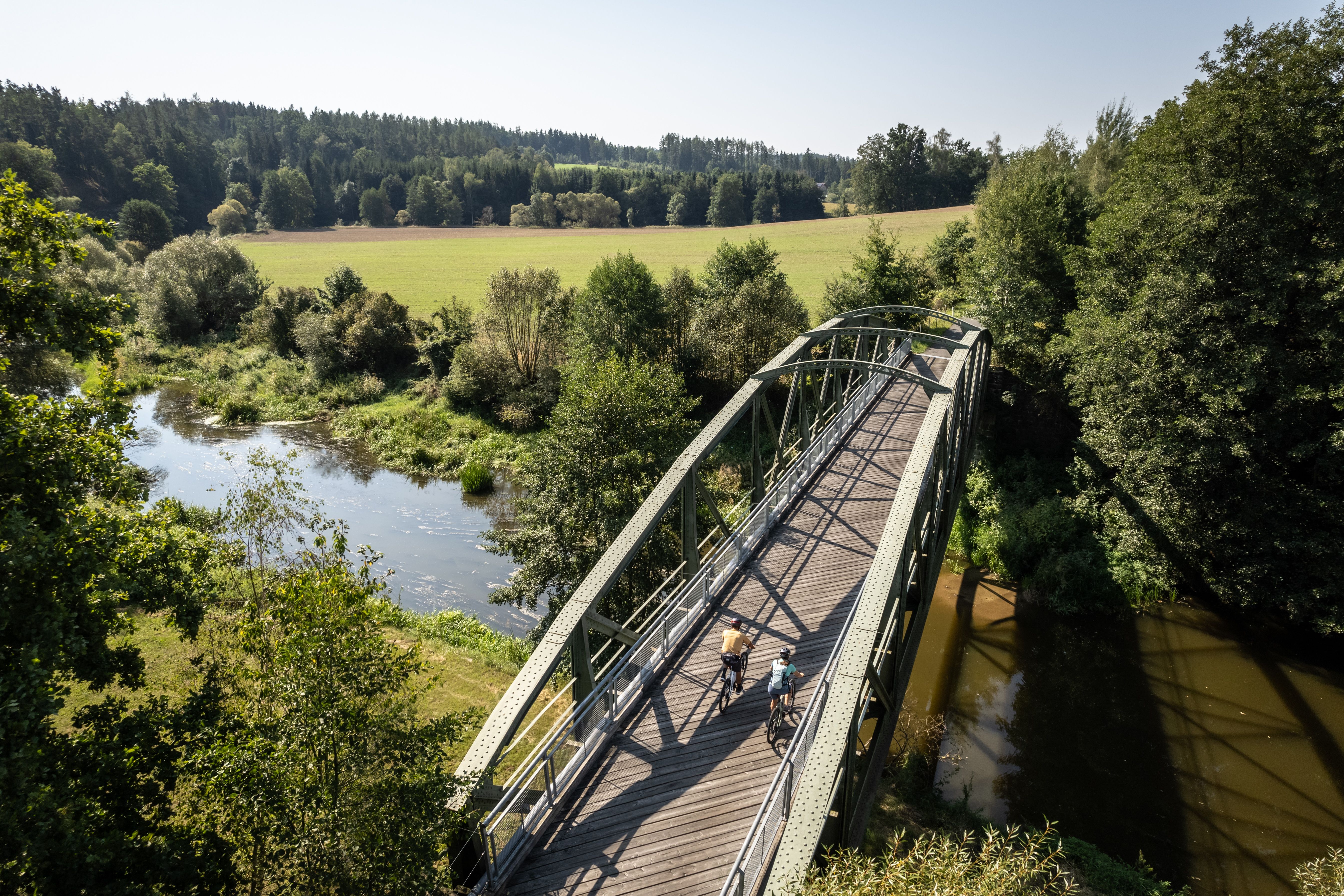 Die sanften Hügel und weitläufigen Felder laden zu einer erfrischenden Radtour ein. Radfahrer genießen die idyllische Landschaft, während die Sonne über den Horizont strahlt und die Wolken sanft am Himmel treiben. Ein perfekter Tag, um die Natur in ihrer vollen Pracht zu erleben.