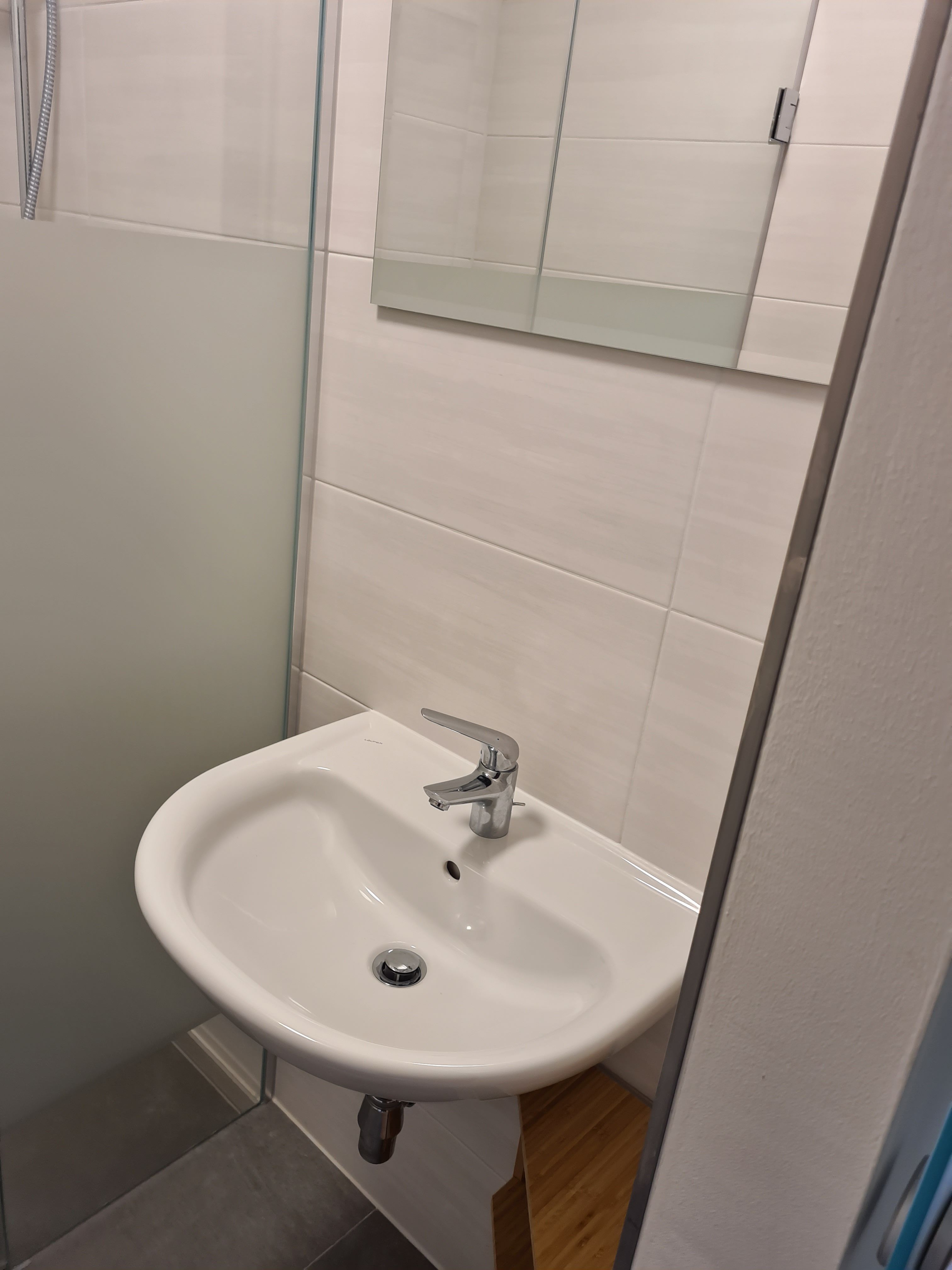 Modernes Badezimmer mit Waschbecken und Spiegel.