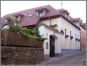 Traditionelles Haus mit rotem Ziegeldach und Blumenkästen an den Fenstern.