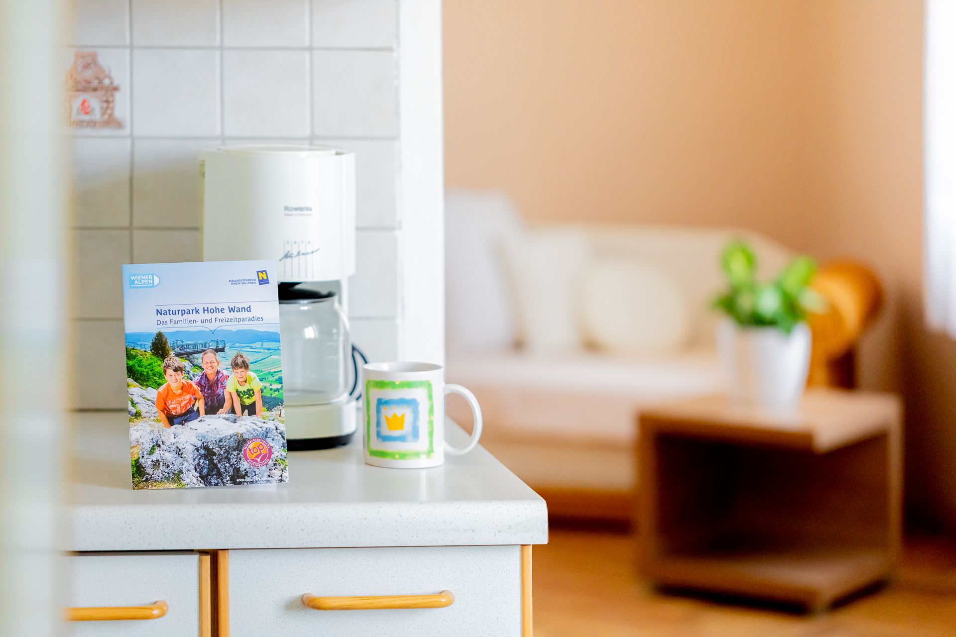 Küchenarbeitsplatte mit Broschüre, Kaffeetasse und Kaffeemaschine.