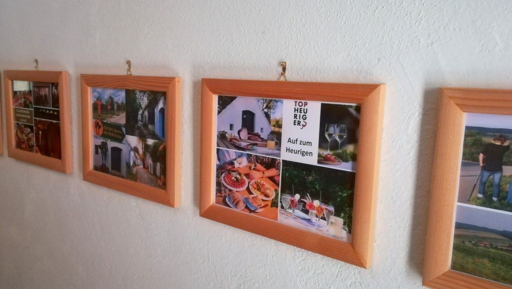 Eine Reihe von Bilderrahmen mit Fotos an einer weißen Wand.