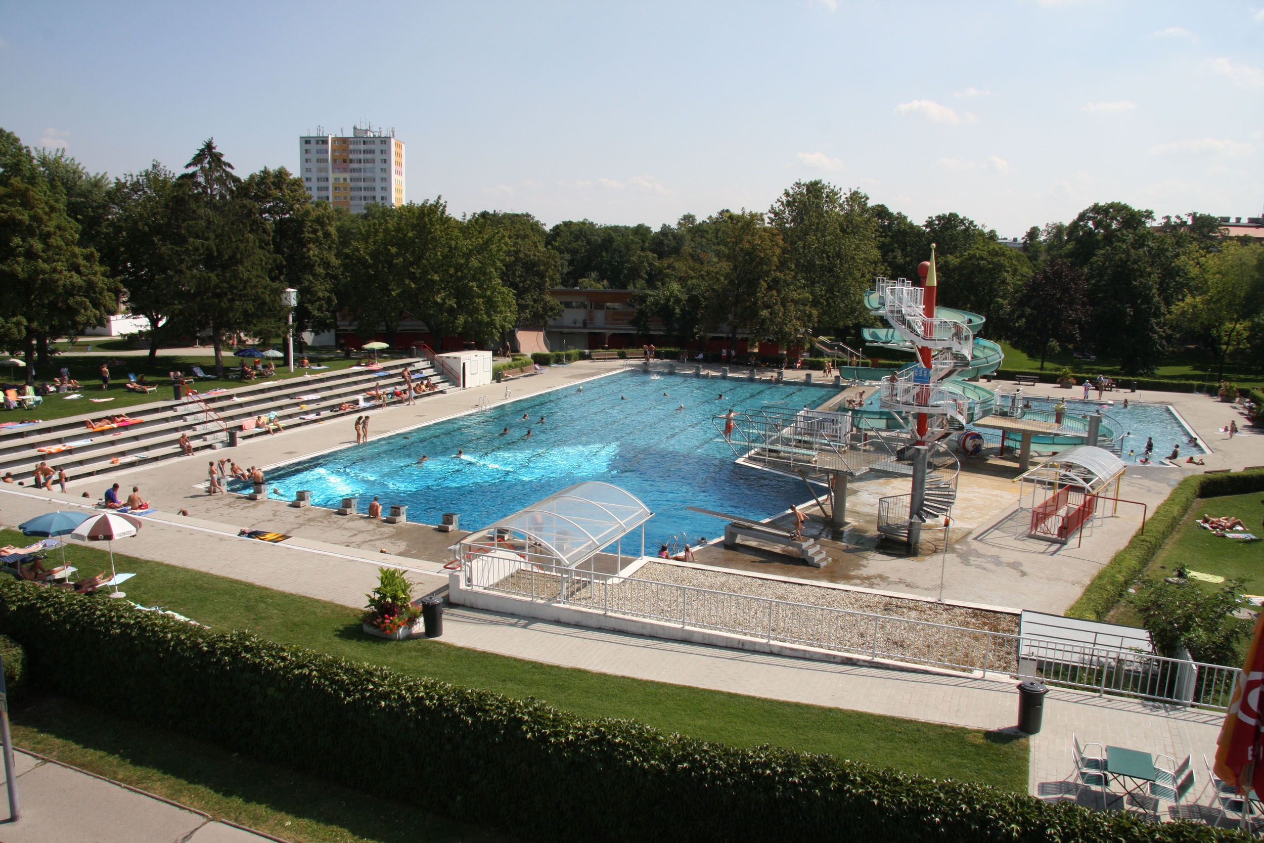 Freibad mit Schwimmbecken, Wasserrutsche und Liegewiese.
