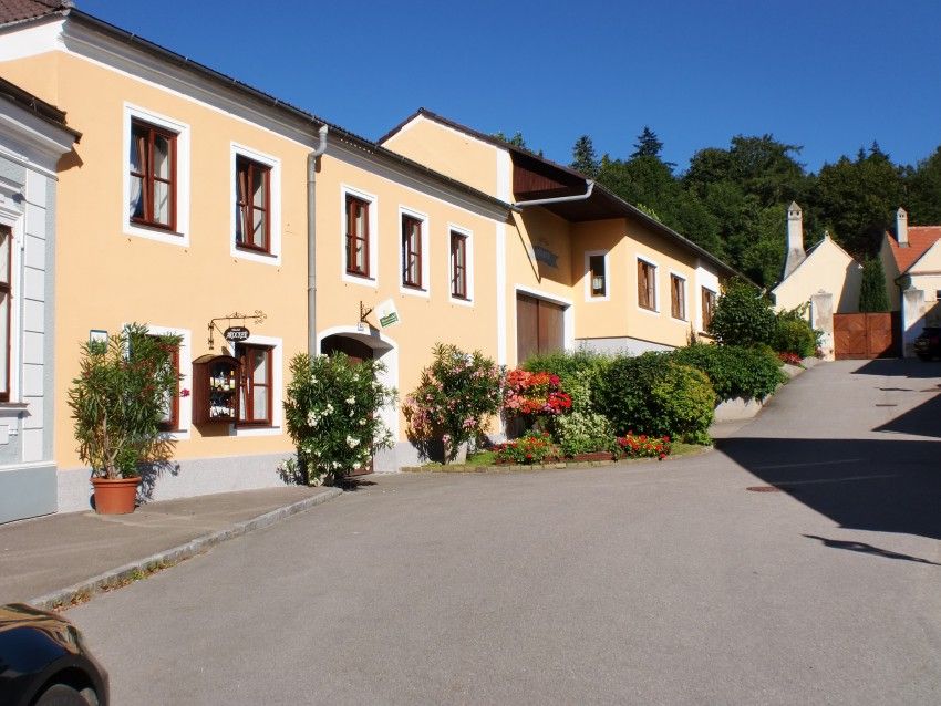 Gelbes Haus mit Blumen und blauen Himmel im Hintergrund.