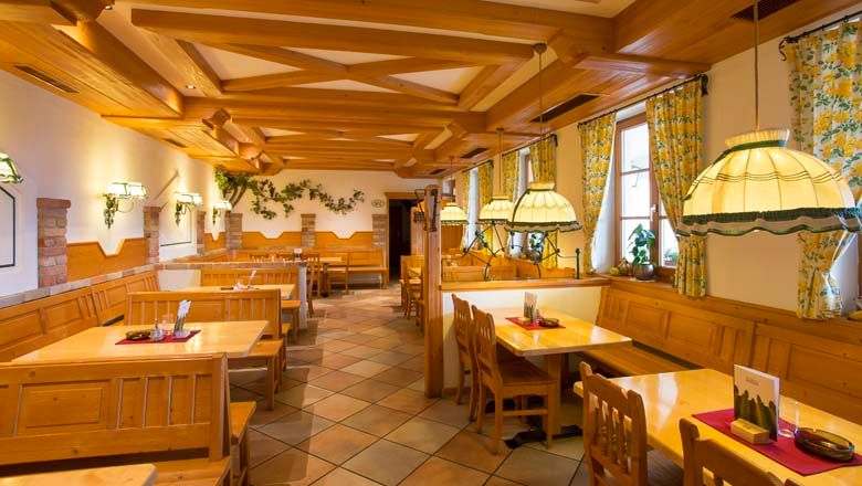 Innenansicht eines traditionellen Heurigenlokals mit Holzmöbeln und gemütlicher Beleuchtung.