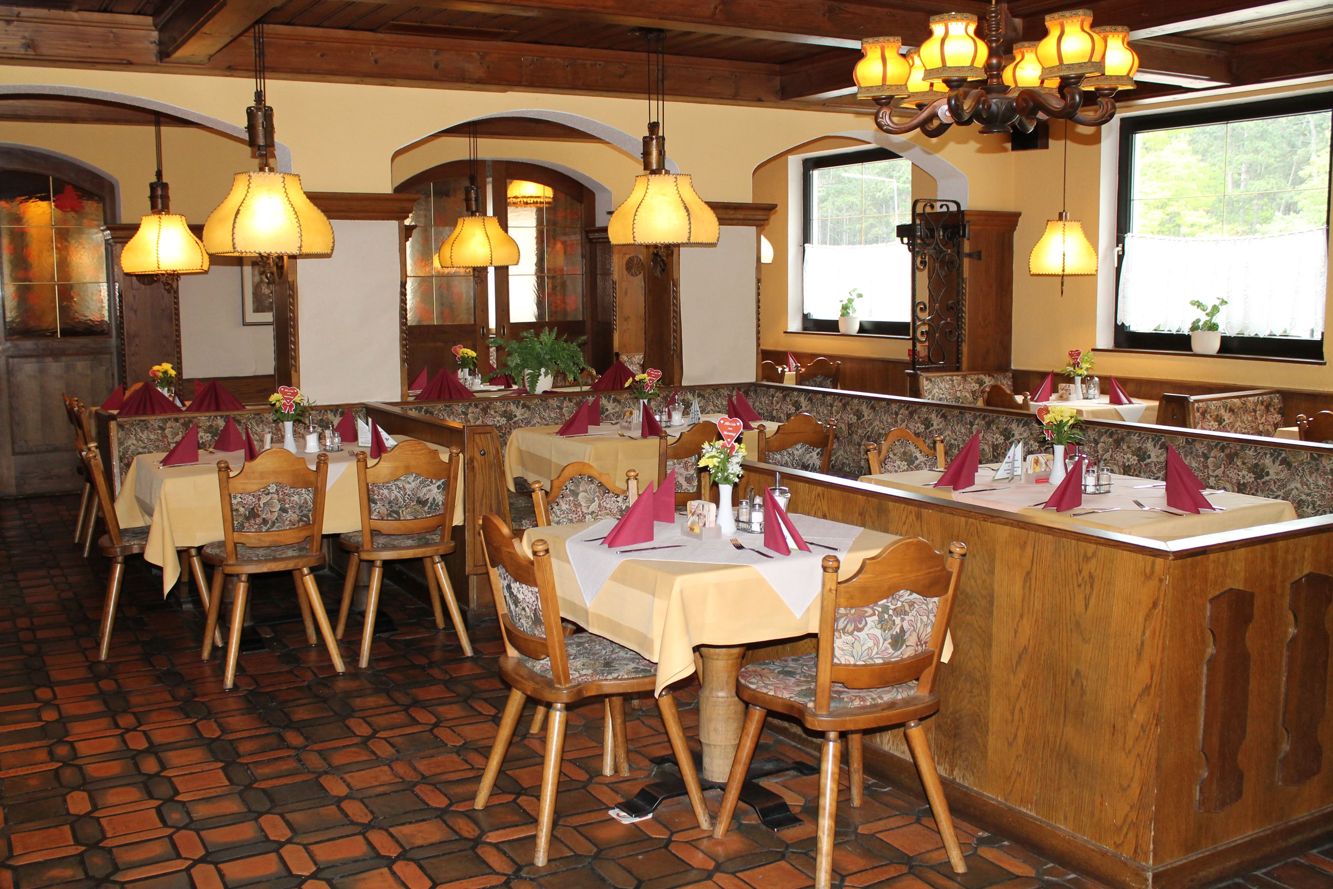 Gemütliches Restaurant mit Holzmöbeln und gedeckten Tischen.