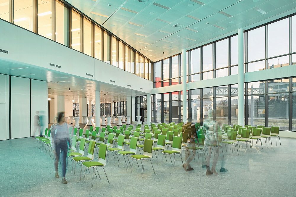 Moderner Konferenzraum mit grünen Stühlen und großen Fenstern im Vienna Airport Conference & Innovation Center.
