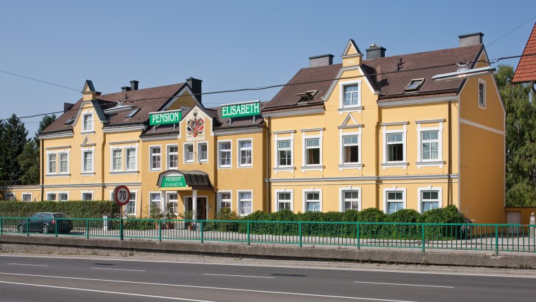 Pension Elisabeth, © Werner Jäger Gelbes Gebäude der Pension Elisabeth mit grünen Schildern.