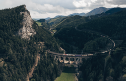 Umgeben von majestätischen Bergen und dichten Wäldern schlängelt sich die Semmeringeisenbahn elegant durch die Landschaft. Die beeindruckende Brücke, die über das grüne Tal führt, bietet atemberaubende Ausblicke und lädt zu unvergesslichen Erlebnissen in der Natur ein.
