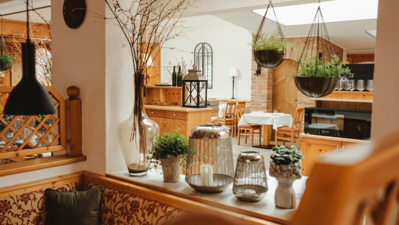 Gem&uuml;tliches Restaurant mit Holzm&ouml;beln und Pflanzen.