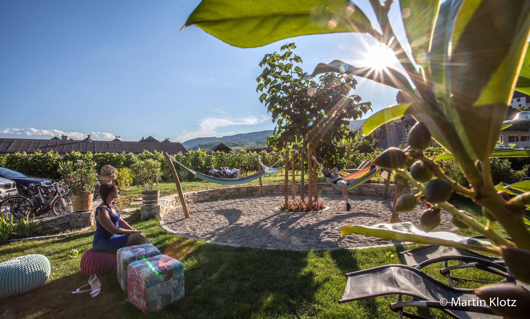 Mediterraner Garten mit Hängematten und Personen, die entspannen.