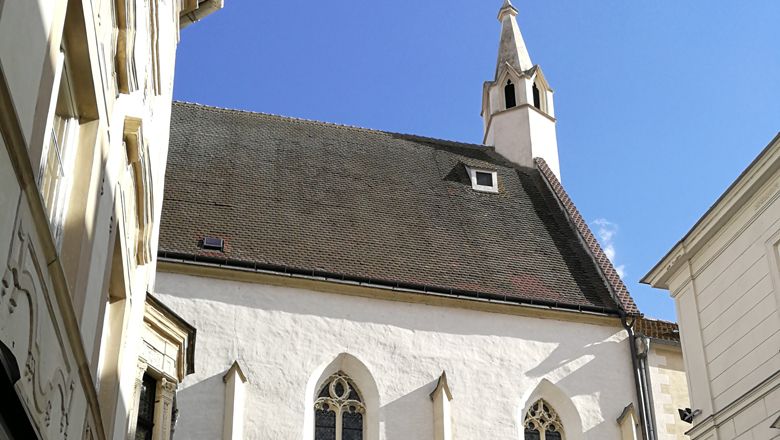 Bürgerspitalskirche in Krems mit spitzem Turm und gotischen Fenstern.