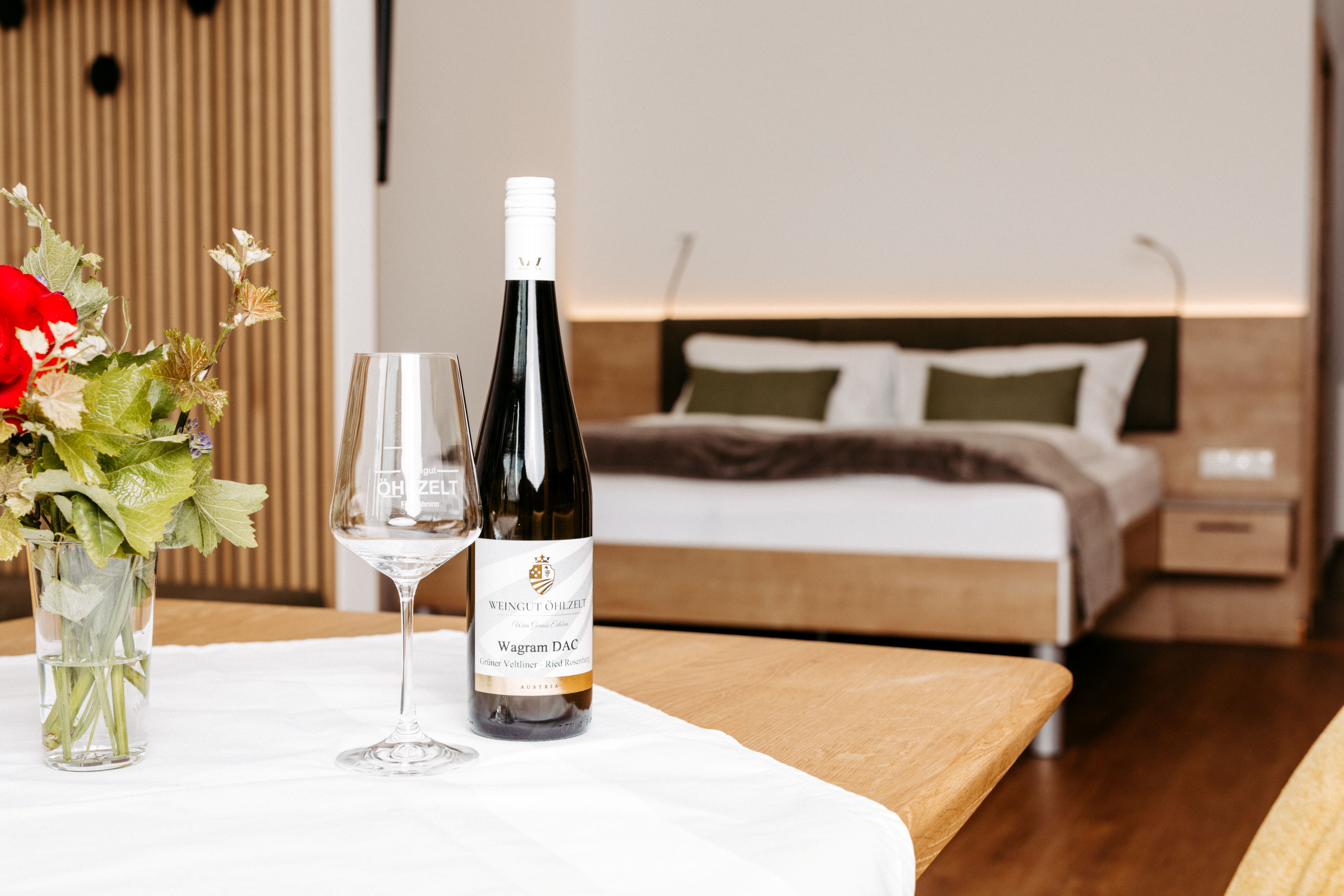Urlaub am Wagram: Modernes Gästezimmer mit Doppelbett, regionalem Wein und gemütlicher Wohlfühlatmosphäre.