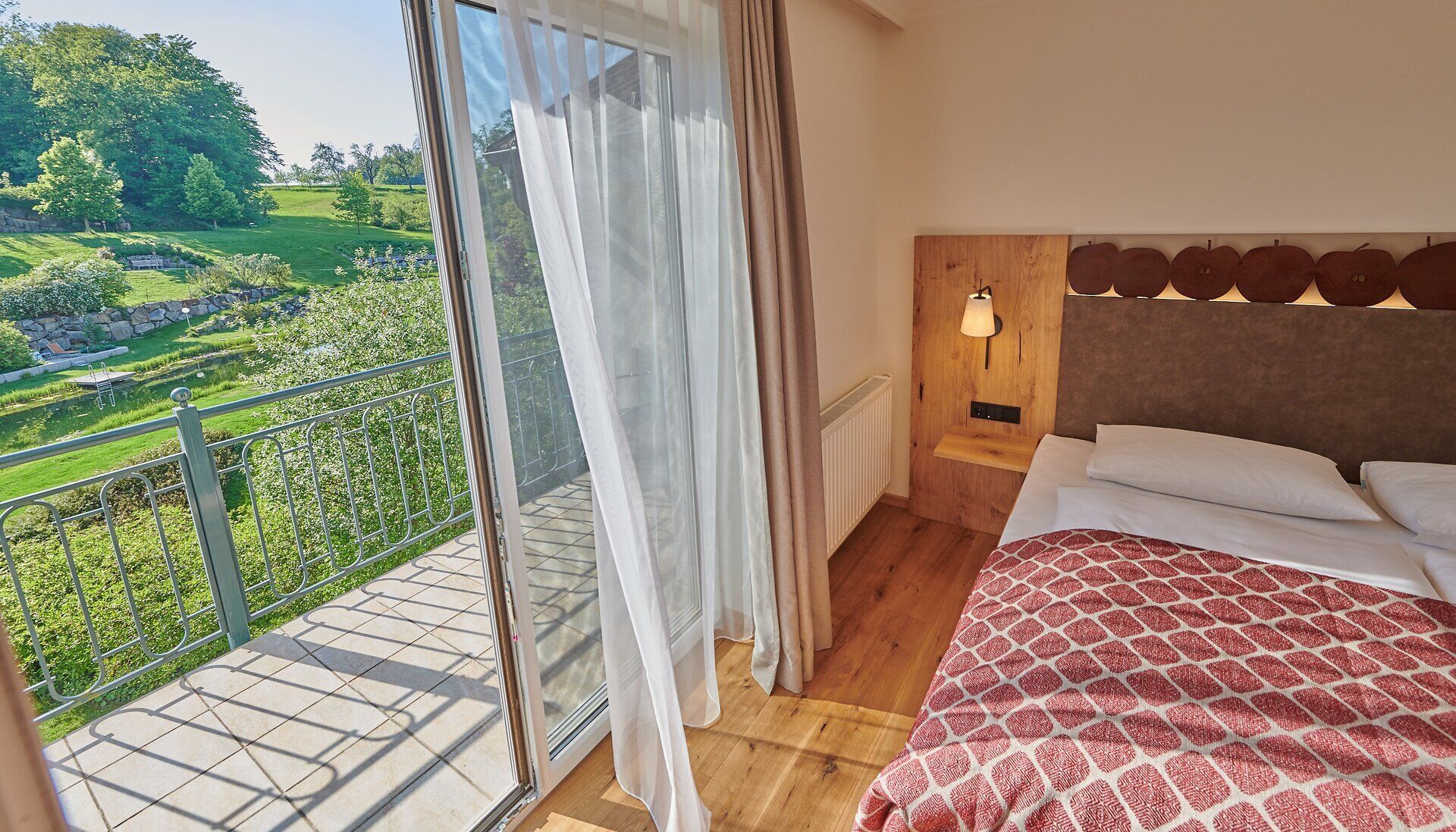 Schlafzimmer im Relax Resort Kothmühle mit Doppelbett und offenem Balkon mit Blick in den wunderschönen Garten, Neuhofen an der Ybbs im Mostviertel.