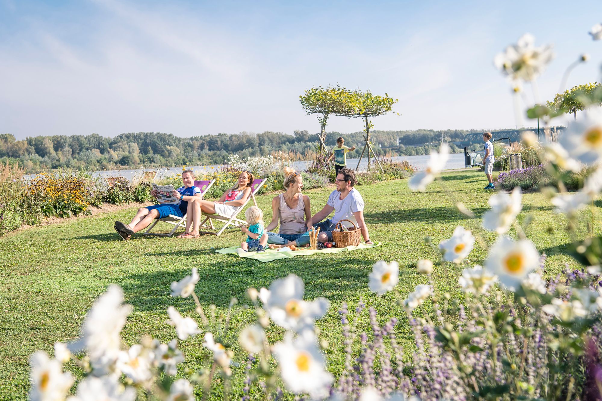 Blühender Garten und Inseln zum sitzen besucht von Gästen auf Picknickdecken 