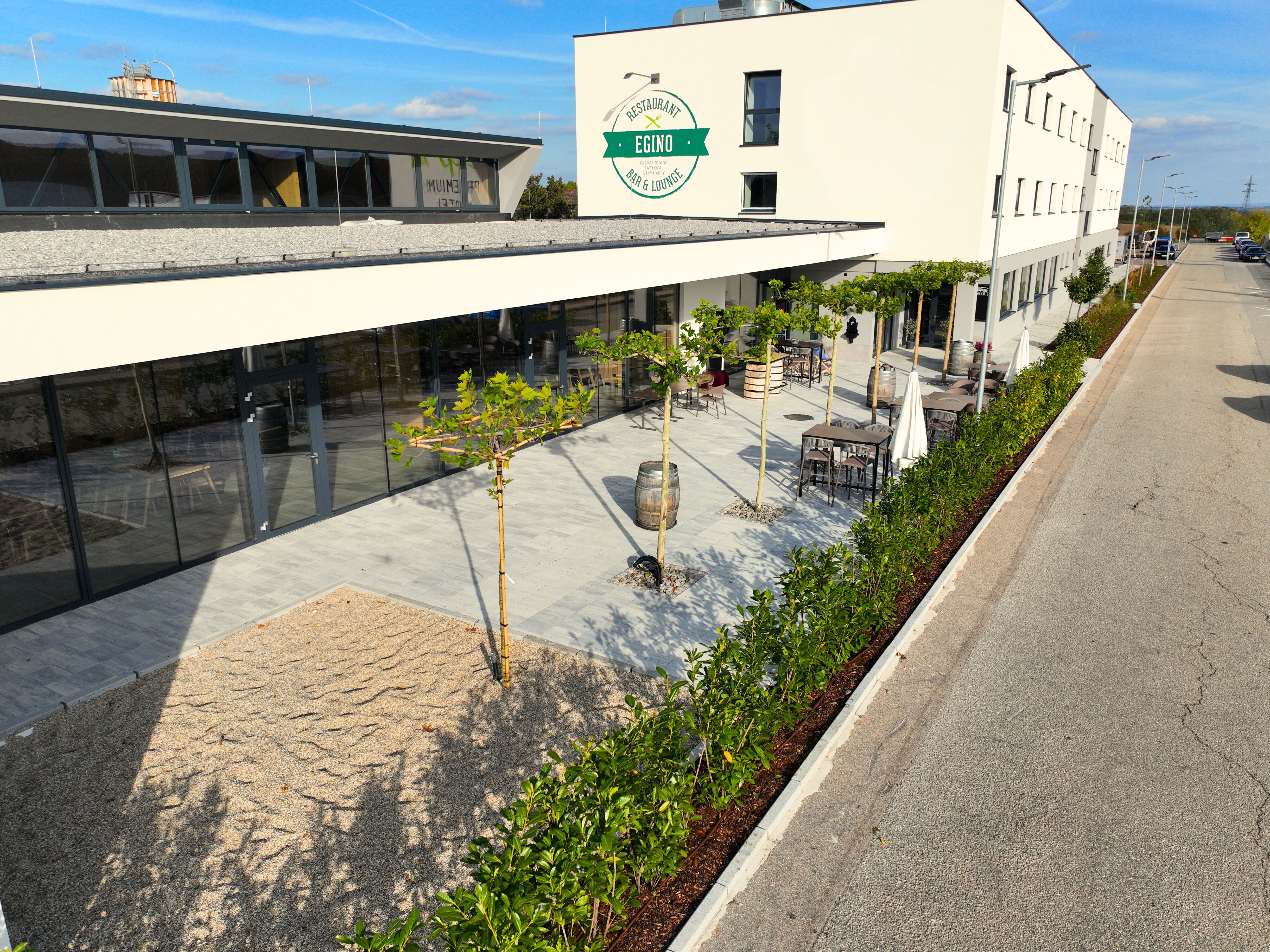 Außenansicht eines modernen Gebäudes mit Terrasse und Pflanzen.