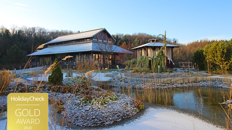 Asiatisch inspiriertes Geb&auml;ude mit Teich und Winterlandschaft.