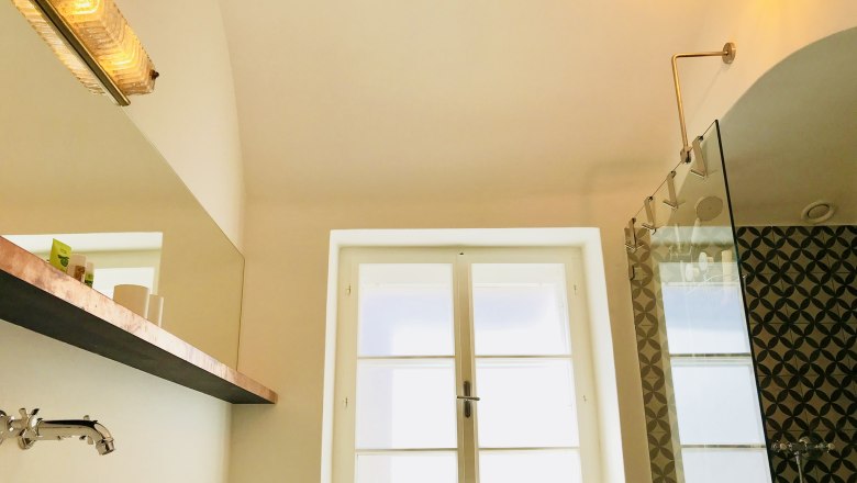 Modernes Badezimmer mit Glasdusche und dekorativen Fliesen.