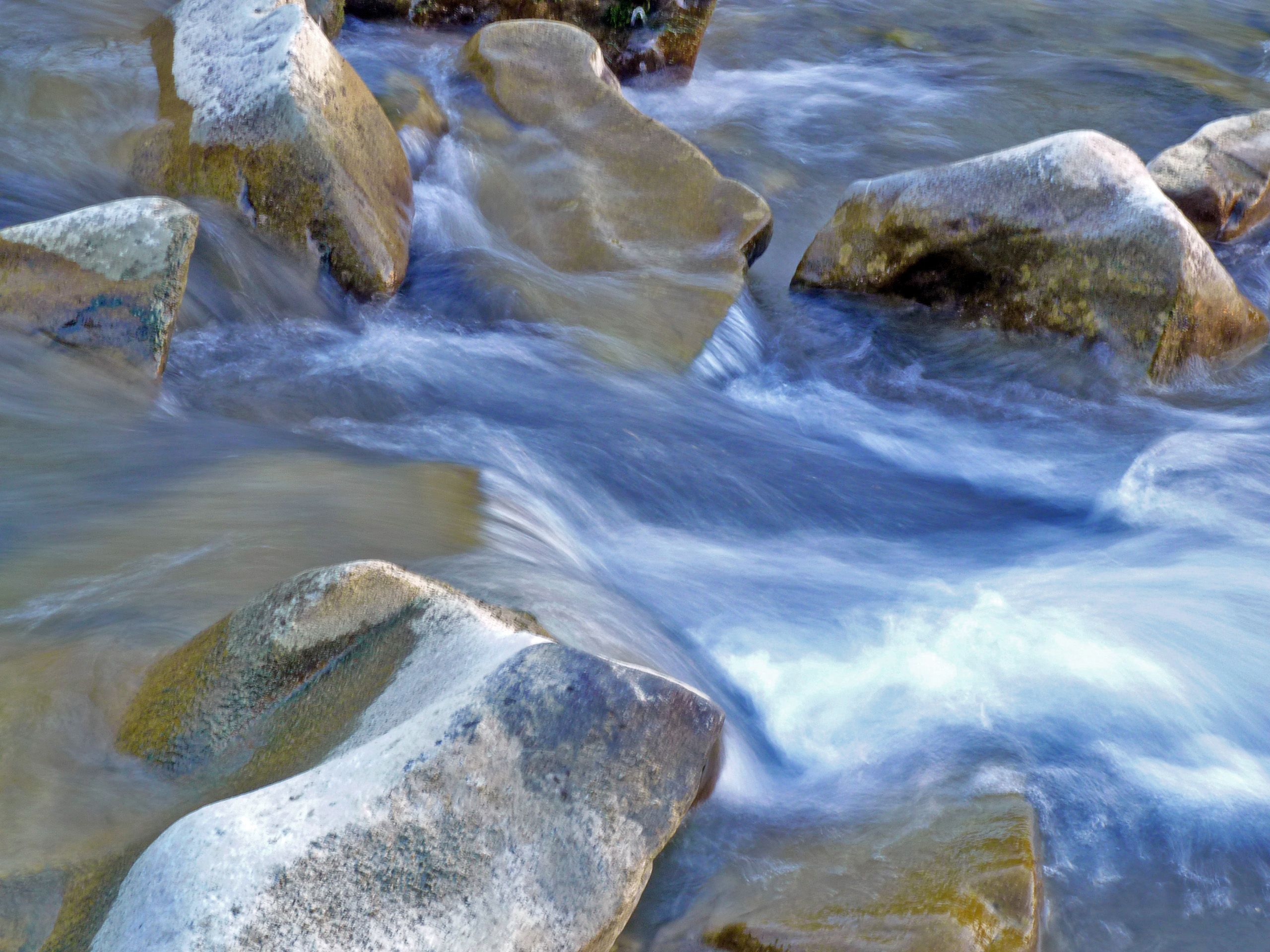 Fließendes Wasser über Steine in einem Bach.