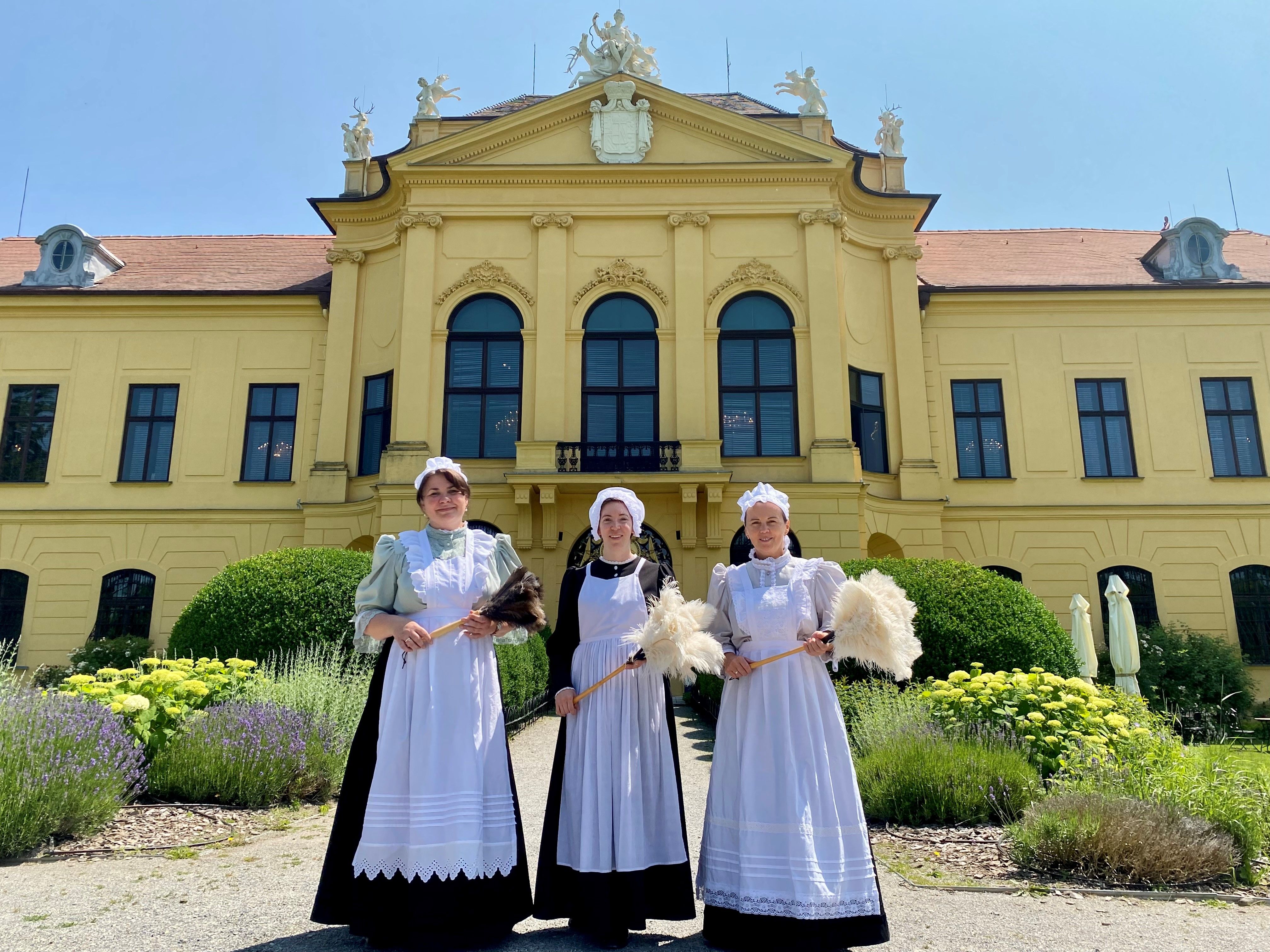Drei Damen im Dienstbotenkostüm vor dem Schloss Eckartsau.