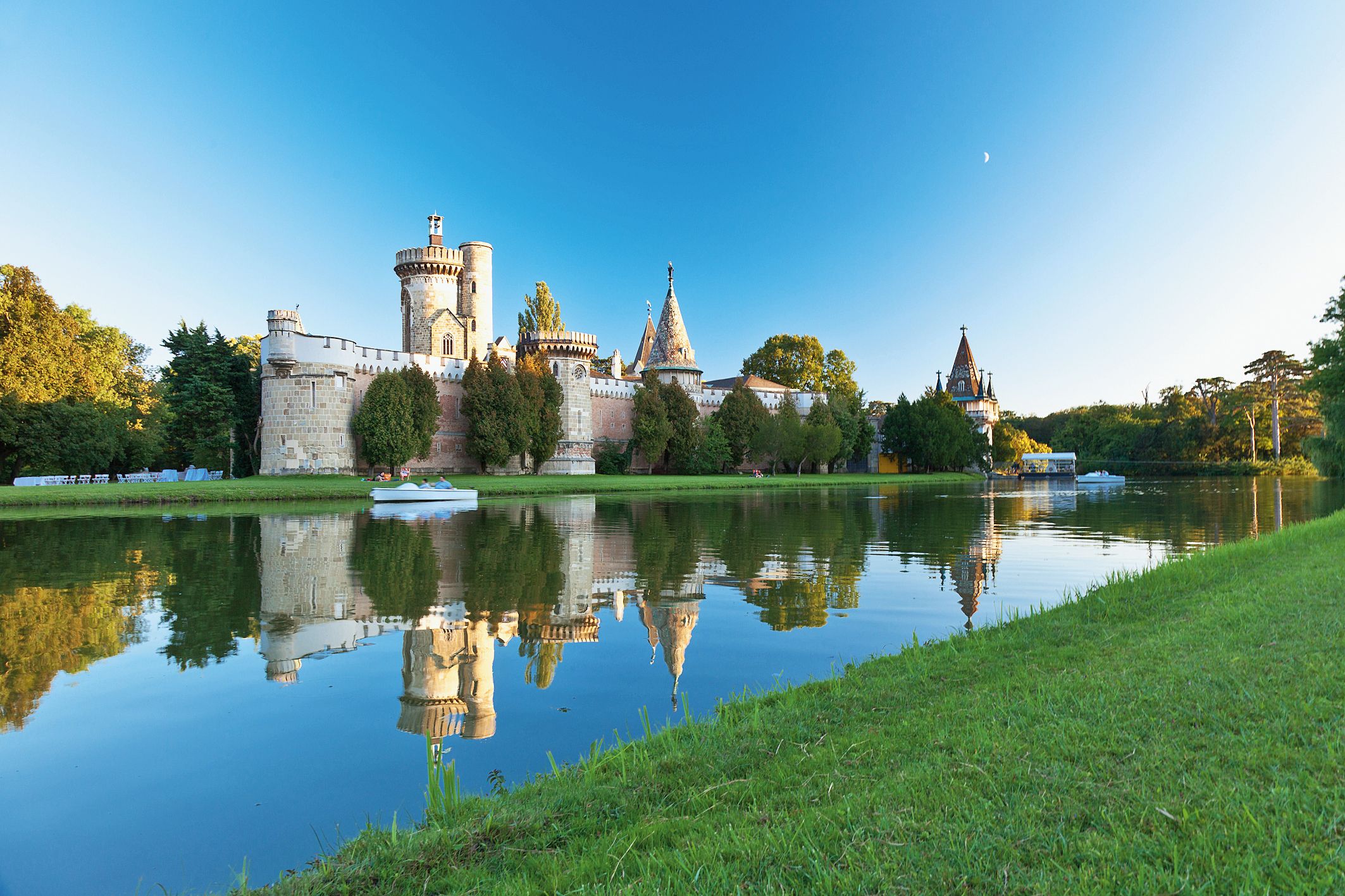 Franzensburg in Laxenburg, umgeben von Wasser und Bäumen, bei klarem Himmel.