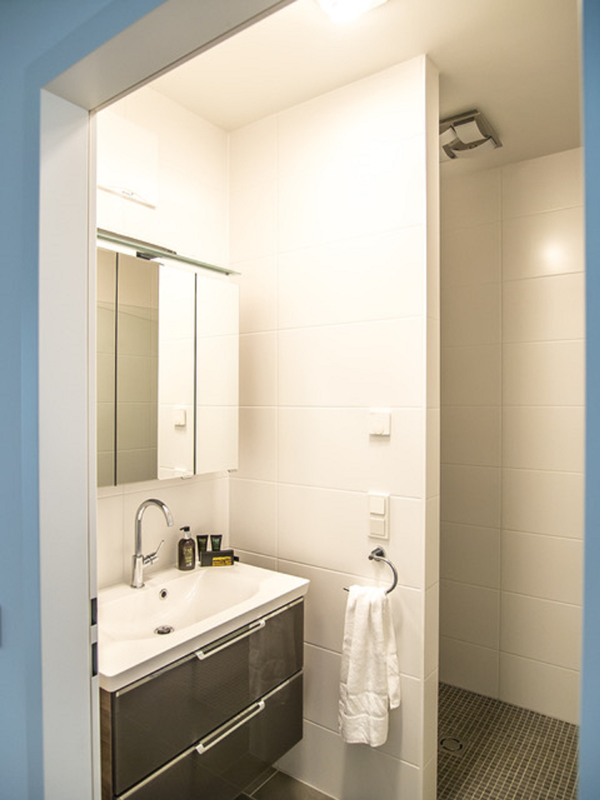 helles einladendes Badezimmer mit Waschbecken und Dusche 