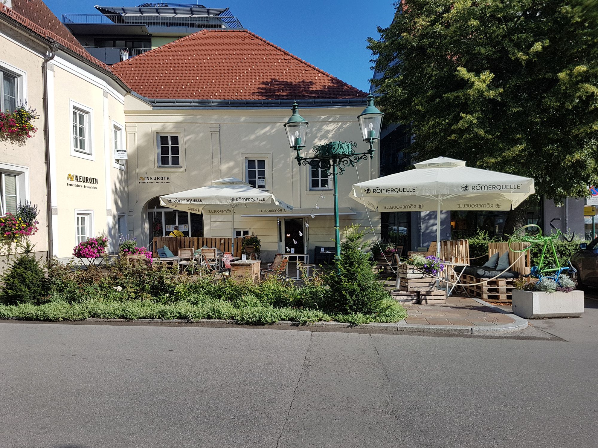 Café von außen, gelbe Fassade 2 Sonnenschirme