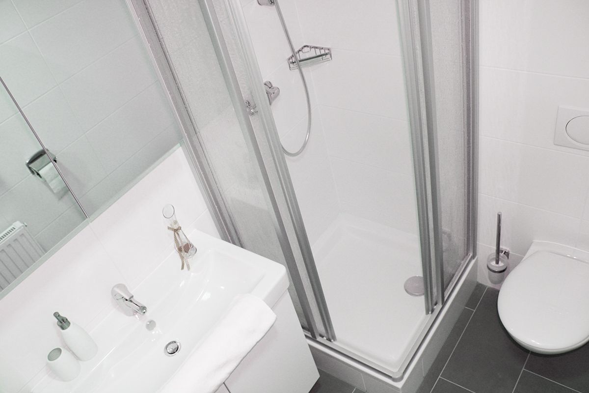 Modernes Badezimmer mit Dusche, Waschbecken und Toilette.