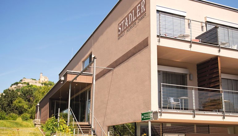 Weingut Stadler, © Georg Wilke Modernes Gebäude des Weinguts Stadler mit Terrasse und Burg im Hintergrund.