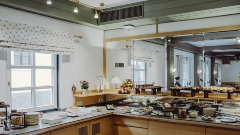 Fr&uuml;hst&uuml;cksbuffet in einem Hotel mit Spiegelwand und Fenstern.