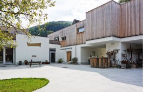 Modernes Geb&auml;ude mit Holzverkleidung und Innenhof.