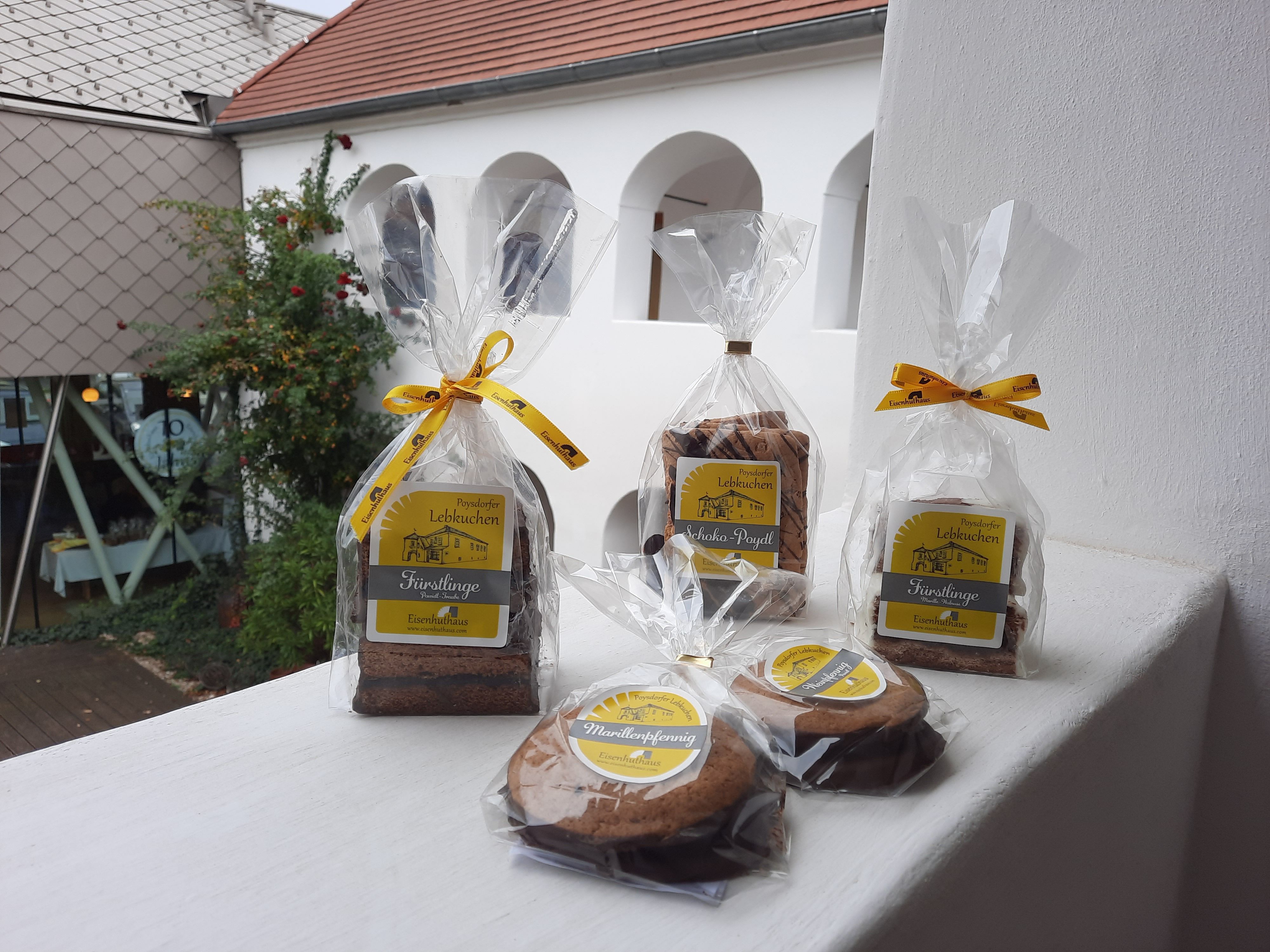 Abgepackter Lebkuchen im Vordergrund, weißer Arkadenhof im Hintergrund.