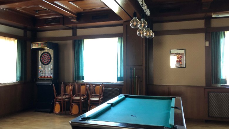 Innenansicht eines Gasthauses mit Billardtisch und Dartautomat.