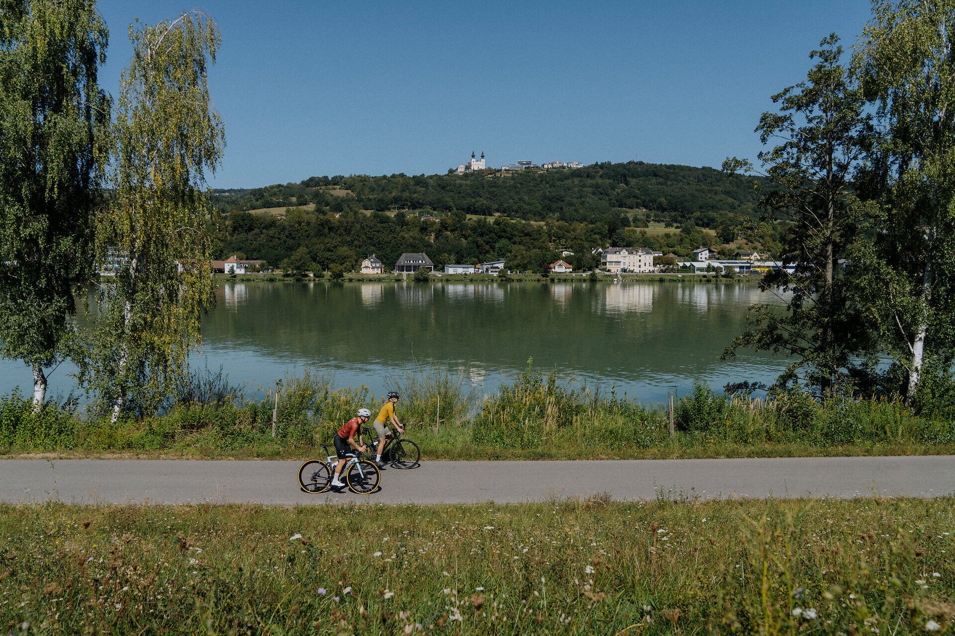 2 Radfahrer am Donauradweg unterwegs im Nibelungengau mit Blick auf die Donau und Maria Taferl