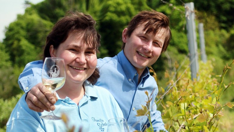 Zwei Personen in einem Weinberg mit Weingl&auml;sern.