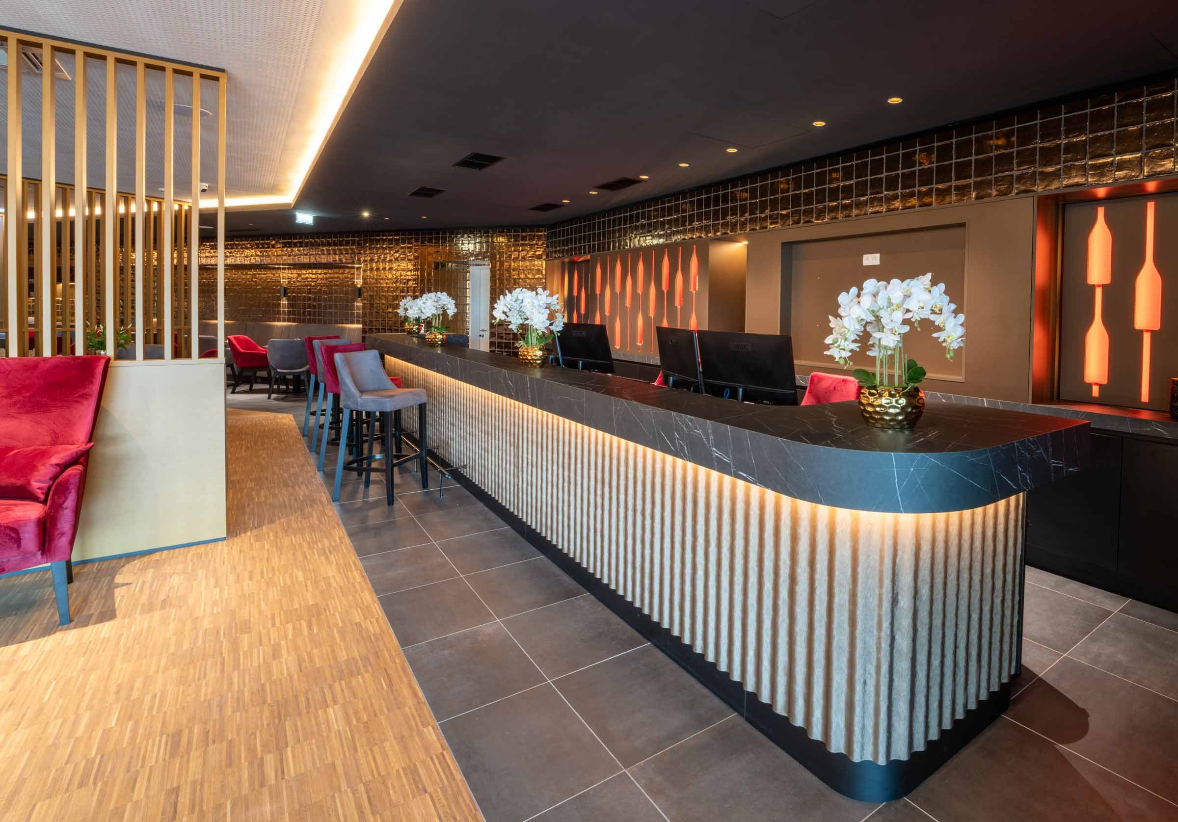 Moderne Hotelrezeption mit stilvoller Beleuchtung und Dekoration.