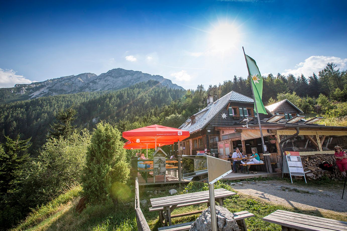 Edelweisshütte am Schneeberg mit Sonnenschirmen und Bergkulisse.