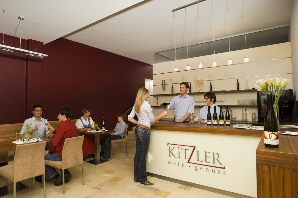 Innenansicht einer Weinbar mit Gästen und Personal.