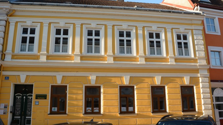 Haus Barbara in Pöchlarn_Außenfassade, © Haus Barbara Gelbes Gebäude mit weißen Fensterrahmen und dekorativen Elementen in Pöchlarn.