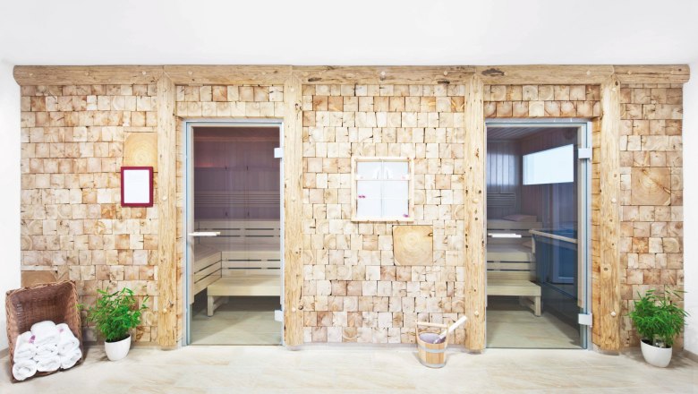 Zwei Saunakabinen mit Holzw&auml;nden und Glast&uuml;ren in einem Wellnessbereich.